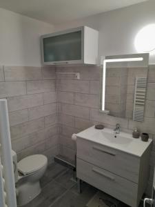 La salle de bains est pourvue d'un lavabo, de toilettes et d'une télévision. dans l'établissement Studio Cabine Sète Corniche Vue Mer, à Sète