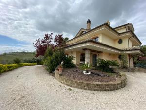 a house with a gravel driveway in front of it at Villa Civita in Colonnella
