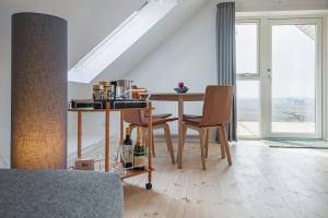 een eetkamer met een tafel en stoelen en een raam bij Hotel Højgaarden in Slettestrand