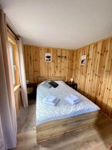 Przycup w Karkonoszach Apartamenty Słoneczna dolina 7B - domek na wyłączność w Karkonoszach في Mniszków: غرفة نوم بسرير وجدران خشبية وارضيات خشبية