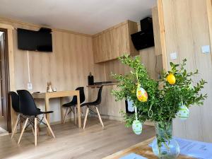 Przycup w Karkonoszach Apartamenty Słoneczna dolina 7B - domek na wyłączność w Karkonoszach في Mniszków: غرفة مع طاولة مع مزهرية مع نبات