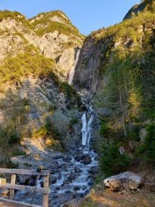una cascata sul fianco di una montagna vicino a un torrente di Gasthof Schwarzer Adler a Steeg