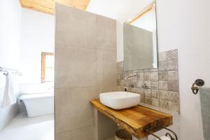 een badkamer met een wastafel, een spiegel en een bad bij 06 On Burger in De Rust