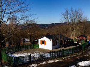 Przycup w Karkonoszach Apartamenty Słoneczna dolina 7B - domek na wyłączność w Karkonoszach في Mniszków: منزل أبيض صغير مع سور أخضر