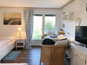 a room with a table and a bed and a window at Kleiner Wattprinz in Nebel