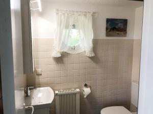 a bathroom with a sink and a toilet and a window at Bungalow "Prinz" in Nebel