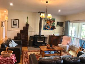 a living room with a couch and a table at Belkampar Retreat - Authentic Farm Style Home - Perfect For Families and Large Groups! in Bonnie Doon