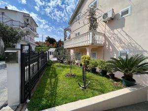 a house with a fence and plants in the yard at Venice Apartments in Tivat