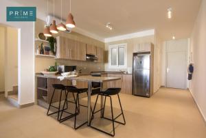 a kitchen with a table and some chairs and a refrigerator at Prime Holidays Seashell in El Alamein