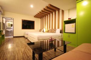 a hotel room with two beds and a coffee table at Windmill Resort Hotel Pattaya in North Pattaya