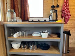 a kitchen shelf with various utensils on it at Pipowagen voor 4 personen in Diever