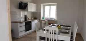 a kitchen with white appliances and a table with chairs at Naša beautiful hause for vecation in Lumbarda