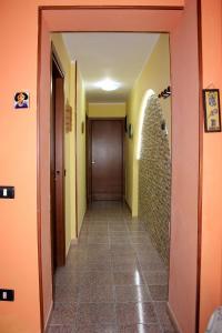 a hallway with orange walls and a door at Apartment Timpirussimare in Sciacca