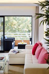 ヴィラモウラにあるMarina Mar Vilamoura Apartmentのリビングルーム(ピンクの枕と白いソファ付)