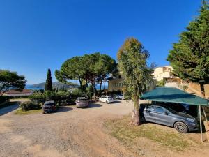 een auto geparkeerd onder een blauwe paraplu op een parkeerplaats bij Mini Appartamenti Elba in Lacona