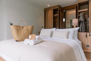a bedroom with a large white bed with towels on it at Villa Alanna Phuket in Bang Tao Beach