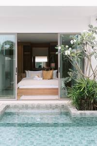 a bedroom with a bed and a swimming pool at Villa Alanna Phuket in Bang Tao Beach