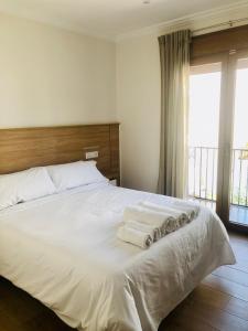 a bedroom with a large white bed with towels on it at El Montoro in Cádiar