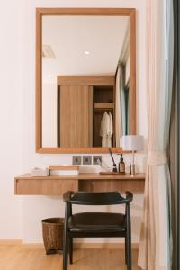 a mirror in a bathroom with a black chair at Villa Alanna Phuket in Bang Tao Beach