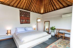 1 dormitorio con cama blanca y escritorio en Yume Villas, en Uluwatu