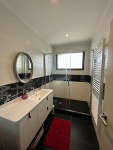 a bathroom with a sink and a shower with a mirror at Villa Raissa marché Arago et les plages in Les Sables-dʼOlonne