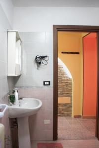 a bathroom with a sink and a mirror and a door at Apartment Timpirussimare in Sciacca