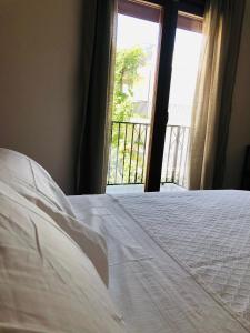 a white bed in a room with a window at El Montoro in Cádiar