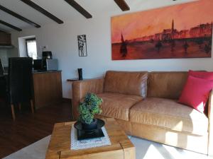 a living room with a brown couch and a table at BBP apartment in Portorož