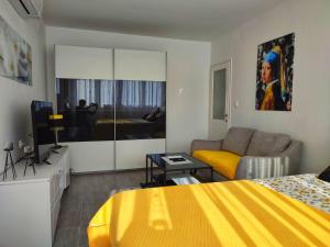 ein Schlafzimmer mit einem gelben Bett und einem Sofa in der Unterkunft Apartment Siesta in Split