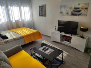 ein Wohnzimmer mit einem Bett und einem TV in der Unterkunft Apartment Siesta in Split