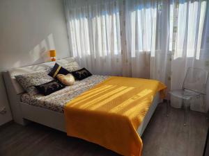 ein Schlafzimmer mit einem Bett mit einer gelben Decke darauf in der Unterkunft Apartment Siesta in Split