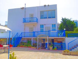 a large white building with blue stairs on it at Le Dune camere in Otranto