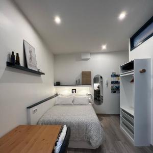 een kleine slaapkamer met een bed en een houten tafel bij MRTN APARTMENTS Studio & Suites - Aix-les-Bains, hypercentre in Aix-les-Bains