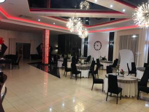 a banquet hall with tables and chairs and a clock at Rodos in Jaczów