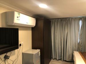 a bedroom with a tv and a bed and a window at شقق المربعة للشقق المخدومة in Ruqaiqah