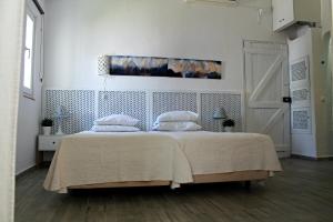 een slaapkamer met een bed met witte lakens en kussens bij Óasis - Pedras D' El Rei T0 in Santa Luzia +15 foto's