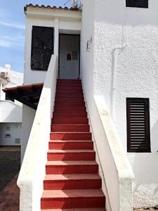 een trap naar een wit gebouw met een deur bij Óasis - Pedras D' El Rei T0 in Santa Luzia