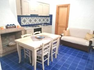 - une cuisine avec une table, des chaises et un canapé dans l'établissement Villetta La Bluette Capo Vaticano, à Capo Vaticano
