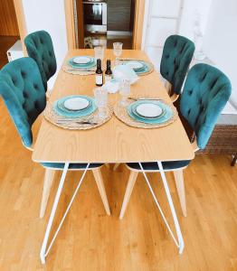 une table en bois entourée de quatre chaises vertes dans l'établissement SoleMare Apartment, à Budva