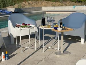 dos mesas con copas de vino y un plato de comida en Pool Villa with view on the Langhe hills, en Mango