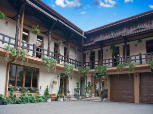 a building with plants on the balconies and a garage at Hotel Galany in Rădăuţi