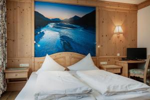 ein Schlafzimmer mit einem Bett und einem Gemälde an der Wand in der Unterkunft Gasthof Schwarzer Adler in Hägerau-Steeg Naturpark Lechtal in Steeg