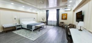 a bedroom with a bed and a table and a desk at Grand Holiday Hall in Pavlodar