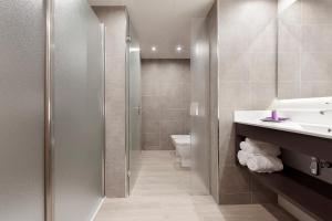 a bathroom with a shower, toilet and sink at Hotel Beverly Park & Spa in Blanes