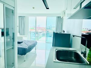 - une cuisine avec évier et un lit dans une chambre dans l'établissement City Center Residence Condominium Pattaya RJ, à Pattaya