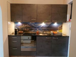 een keuken met zwarte kasten en een wastafel bij 1 Zimmer Apartment mit Seesicht und Pool in Vira