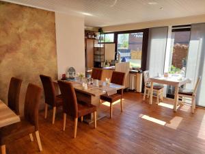 a dining room with a table and chairs at Hotel Rosmarin in Bad Zwischenahn