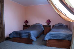 two beds in a small room with two lamps at Motel Prival in Yelets