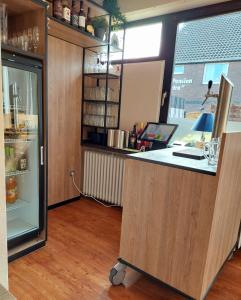 an office with a counter and a refrigerator at Hotel Rosmarin in Bad Zwischenahn