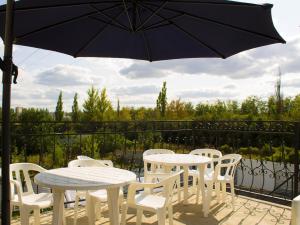 a patio with a table and chairs and an umbrella at Motel Prival in Yelets